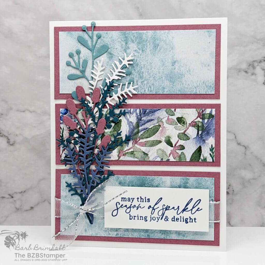 Card make with the Magical Meadow Bundle in purples, blues and greens.   Lots of die-cut ferns on pretty paper.  Sentiment is "may this season of sparkle bring joy & delight."

