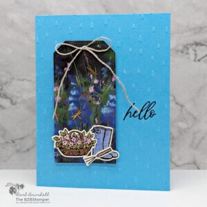 Magical Meadows Bundle from Stampin' Up! in different shades of blues and purples. Features a tag on the front of the card, with hello greeting and flowers, a gardening tool and rainboots.