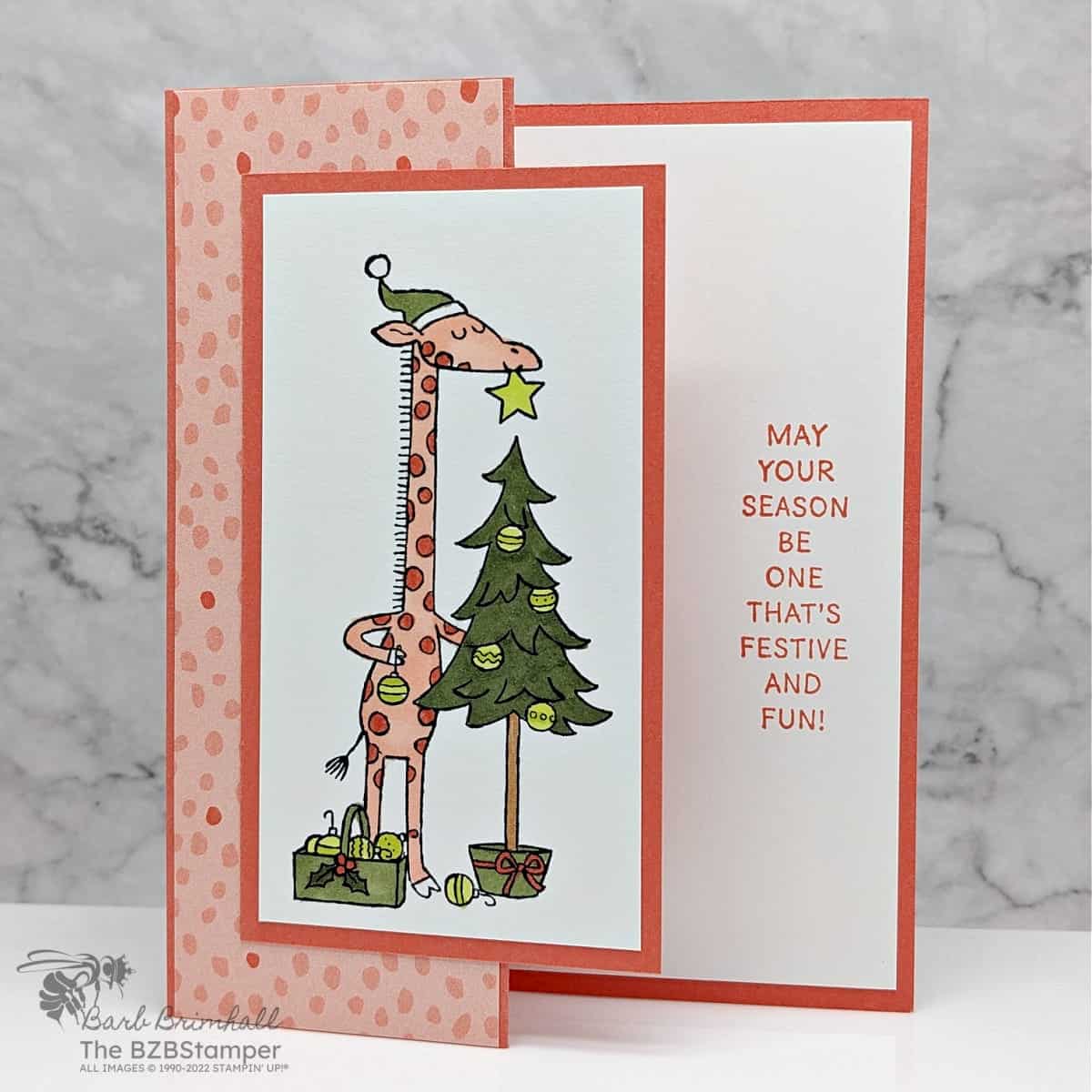 Orange and green Christmas card featuring a giraffee with the sentiment "May your season be one that's festive and fun."