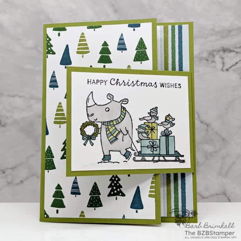 Christmas card in greens and blues featuring a rhino pulling a sled with birds and presents and sentiment "Happy Christmas Wishes."