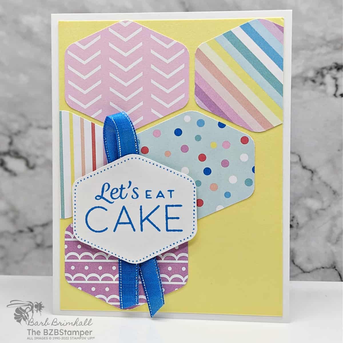 Heartfelt Hexagon Birthday Card featuring hexganon shapes punched from pretty paper in a variety of colors including blue and yellow.  Sentiment is "let's eat cake".