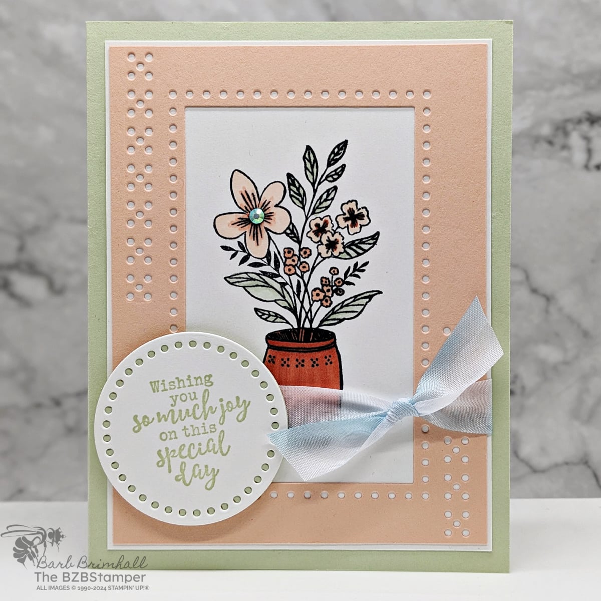Tutorial Featuring The Everyday Details Bundle in light pinks and greens.  Features a vase with flowers and lots of die-cut details, including a sentiment on a circle and a blue ribbon.