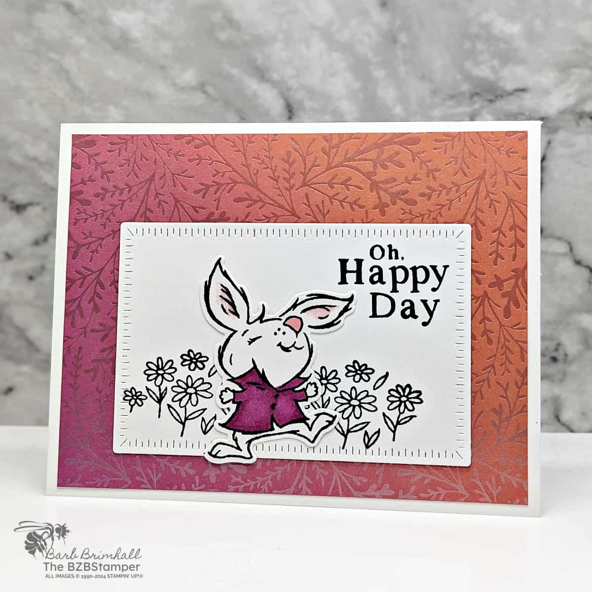 Spring Crafting: Oh Happy Day Bunny Card featuring an orange background paper with a bunny in a purple shirt playing among flowers.