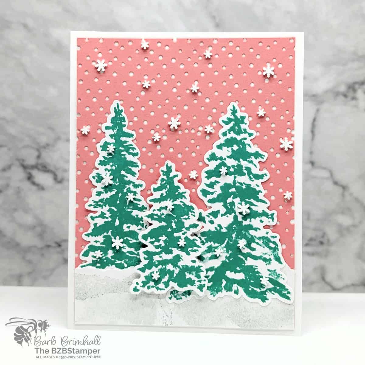 Bright Twist on Winter Peaceful Evergreens Card in bright coral and green.  Dotted die-cut background with 3 fir trees of different sizes and lots of snowflake embellishments.  No sentiment on this card.