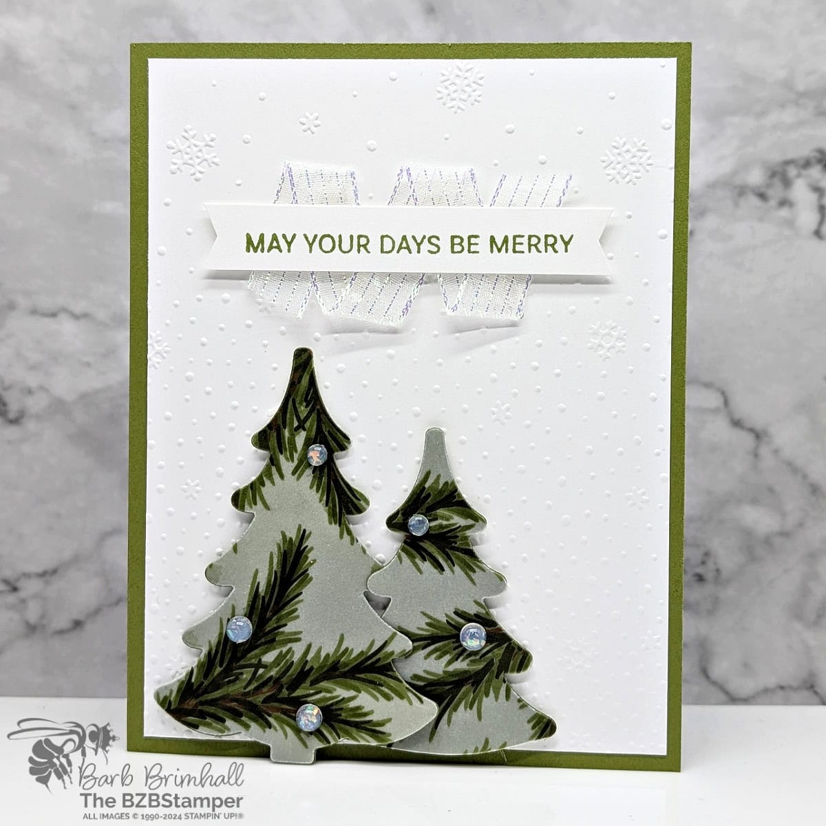 May Your Days Be Merry with the Decorative Trees Bundle featuring 2 Christmas Tree die-cuts, a snow background, and pretty ribbon.  In greens and white.