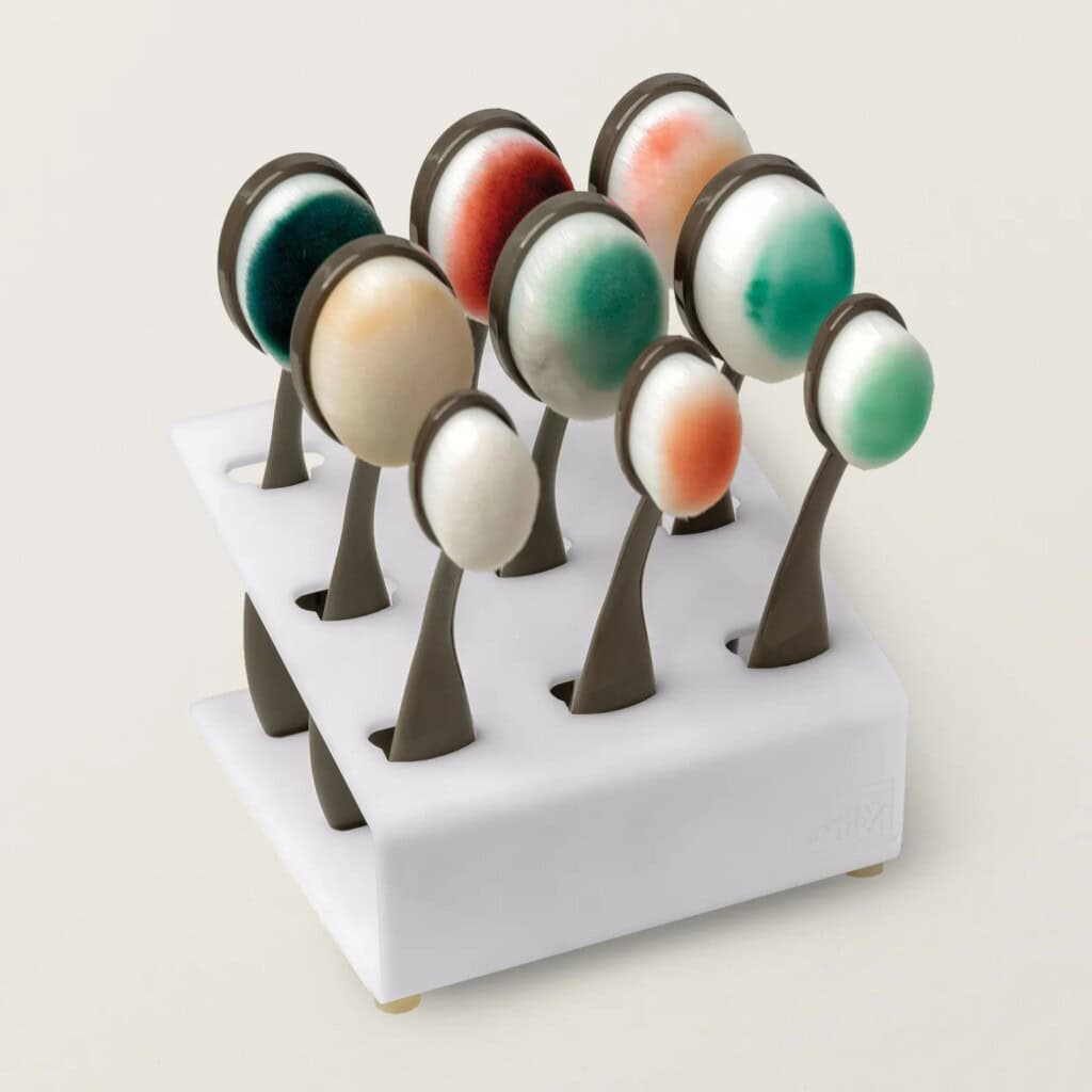 Stampin’ Up! Blending Brushes neatly displayed in a white storage stand, bristles inked with various colors for easy cardmaking organization.