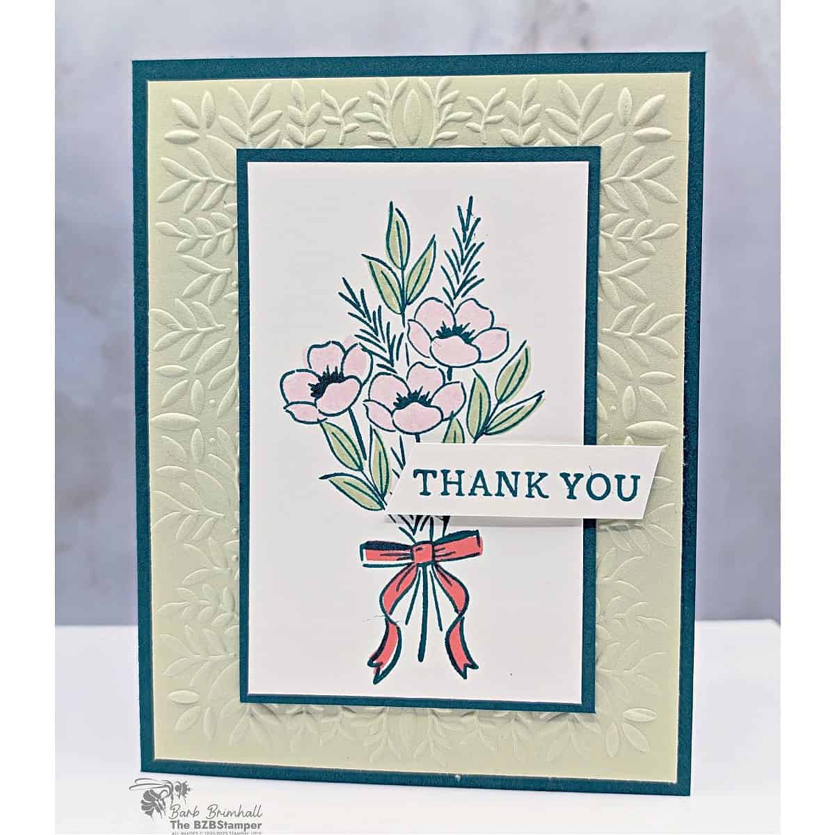 Coffee and a Card with the Christmas Greenery Set and Peaceful Greenery Embossing Folder. Features a bouquet of flowers tied with a bow, layered on an embossed Soft Sea Foam background with Pretty Peacock framing and Flirty Flamingo accents.