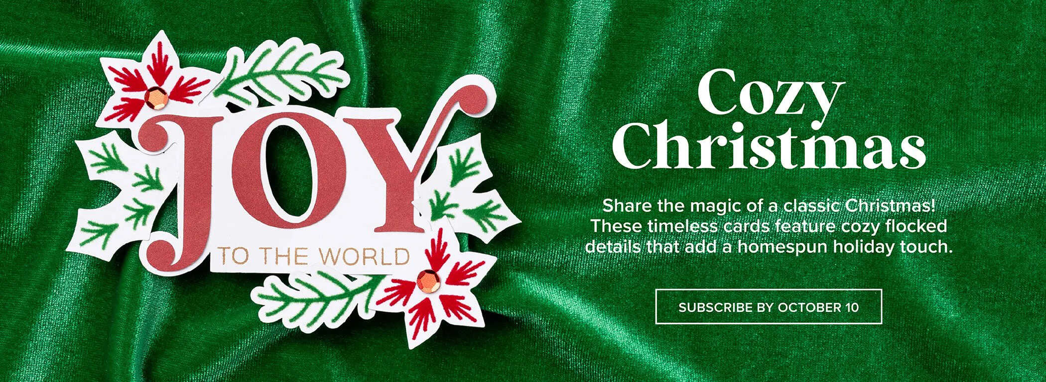 Monthly Crafting Subscription Box featuring Handmade Christmas card with the word “JOY” in bold red letters, surrounded by green leaves and red floral accents, set against a green velvet background with the words Cozy Christmas.