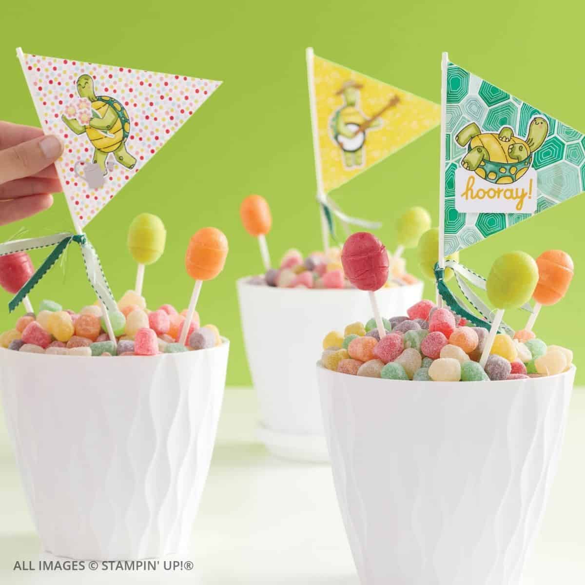 Building Relationships Through Cardmaking. Bright handmade party decorations featuring cheerful turtle flags on sticks set in cups of colorful candies. A fun, creative use of stamping supplies for birthday or celebration décor.