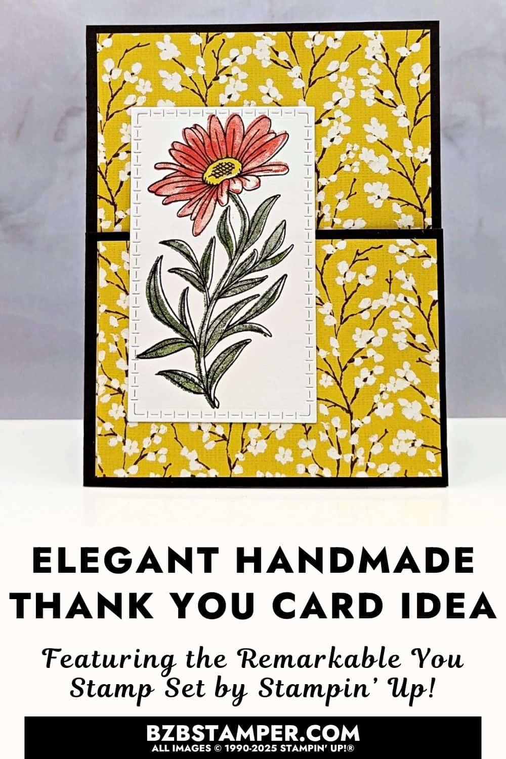 You are Remarkable Stamp Set Coffee and a Card is a handmade card with a deep brown border and a mustard yellow patterned background. Centered on the front is a tall white panel showing a single stamped flower with a coral-pink bloom, yellow center, and green stem and leaves. The flower has a soft shimmer from glitter, and the design feels clean, warm, and elegant.