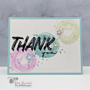 Bright thank you card with colorful circular watercolor splashes and small flower embellishments.