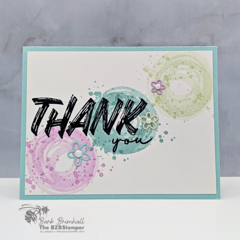 Bright thank you card with colorful circular watercolor splashes and small flower embellishments.