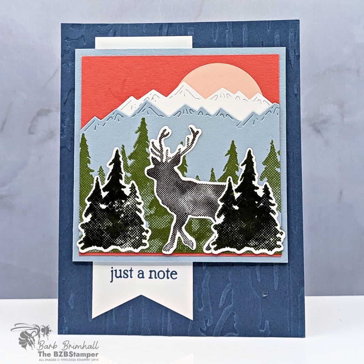 Colorful layered holiday card featuring a reindeer silhouette, mountain, forest, and sunrise scene, created by Barb Brimhall, The BZBStamper.