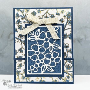 Intricate blue floral paper craft with a textured bow, showcasing handmade stamping and paper crafting techniques.