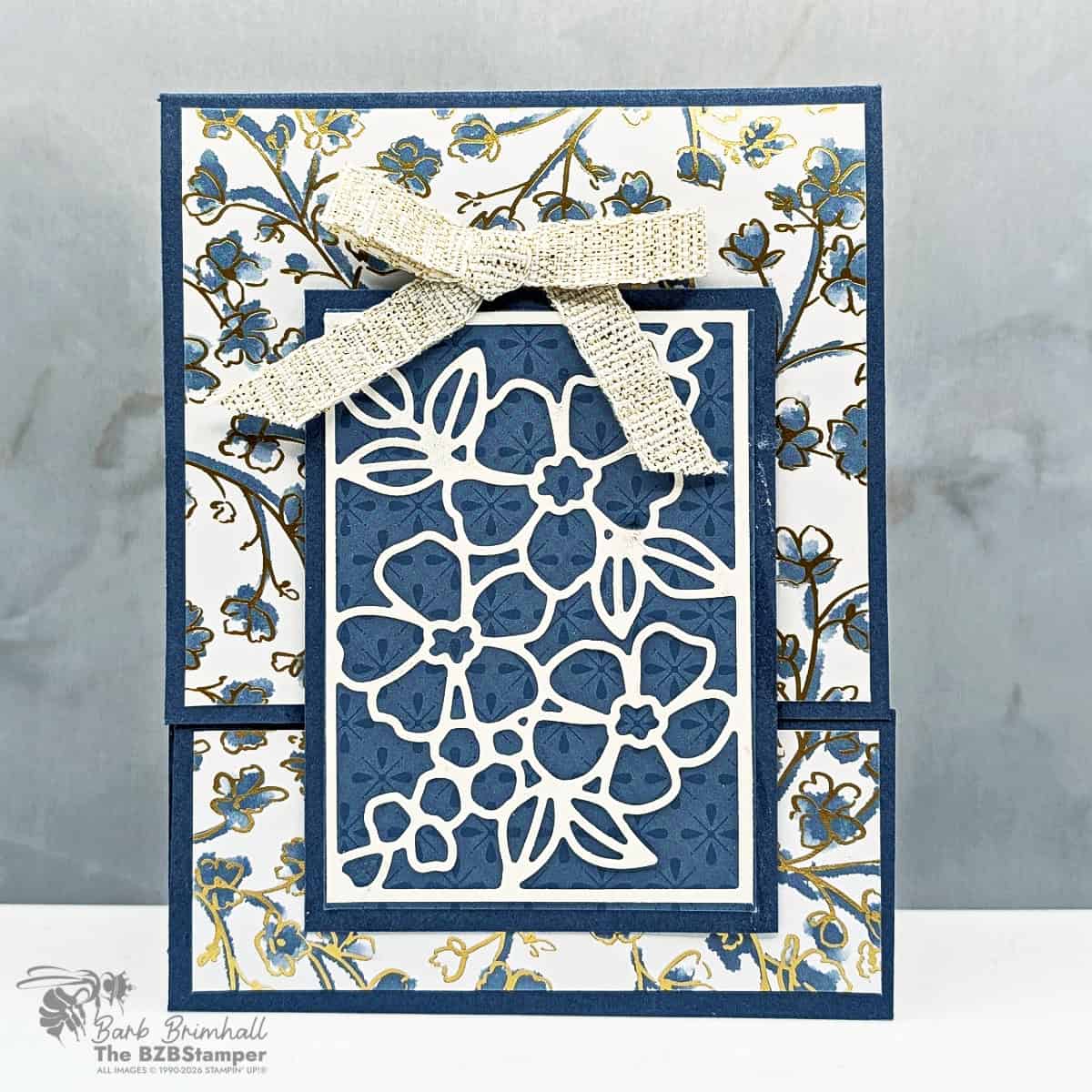 Intricate blue floral paper craft with a textured bow, showcasing handmade stamping and paper crafting techniques.