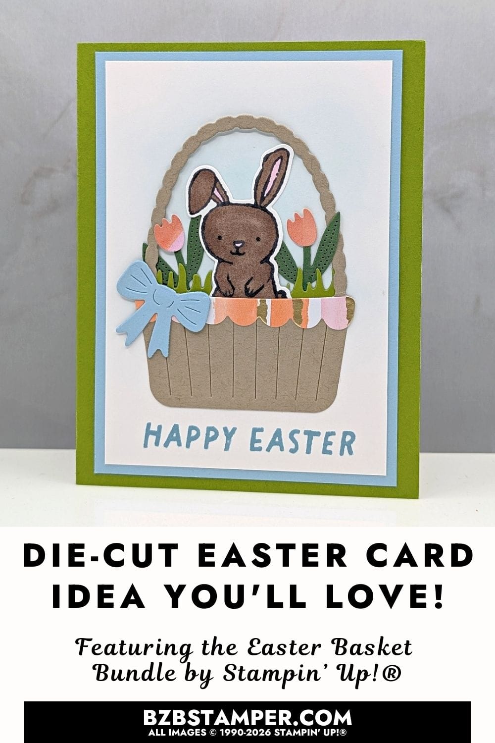 Happy Easter Card Using the Easter Basket Bundle featuring a bright green base and layered panels of white and light blue. A die-cut basket sits in the center, filled with grass, flowers, and a small brown bunny. A soft blue bow is attached to the basket, and a light blue Easter greeting appears below. The overall design feels cheerful, dimensional, and spring-inspired.
