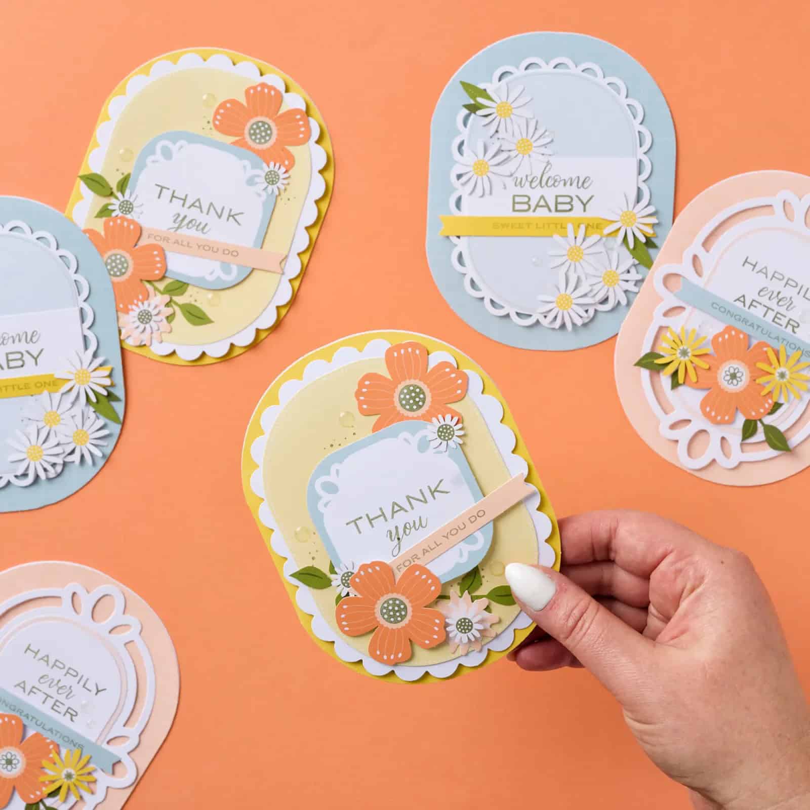Easy Handmade Cards with the Happy Happenings Kit features pastel handmade cards with layered oval designs, floral embellishments, pearl accents, and coordinating envelopes for baby, wedding, and thank you occasions.